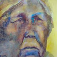 an old woman painted in bright yellows and blues