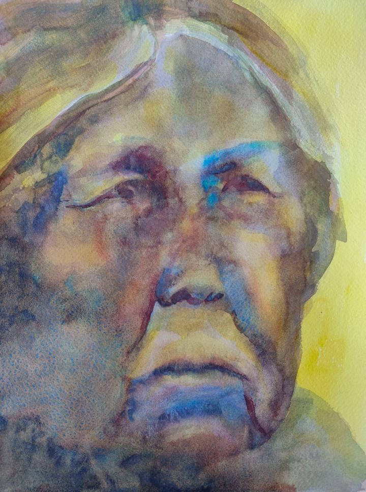 an old woman painted in bright yellows and blues
