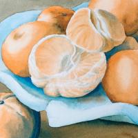 oranges, one peeled, on a blue ceramic serving dish