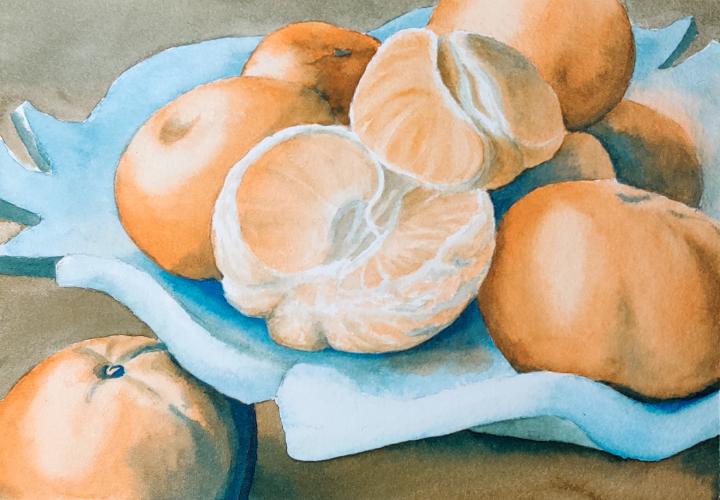 oranges, one peeled, on a blue ceramic serving dish