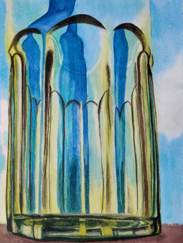 A green octagonal cup stands in front of a blue bottle and shows the refraction of the blue bottle in the column like features of the cup.